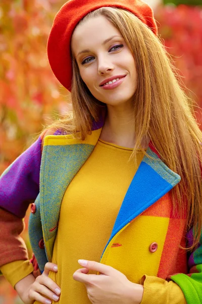 Schöne elegante Frau steht im Herbst in einem Park — Stockfoto