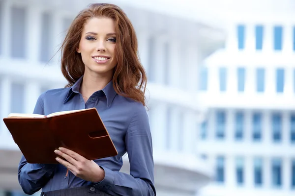 Junge glückliche Frauen oder Studentin mit Hintergrund in der Immobilienbranche — Stockfoto