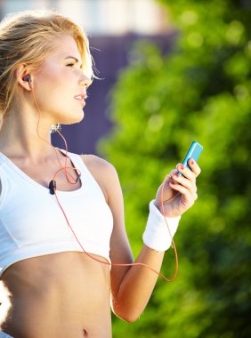 güzel bir kadın fitness şehir üzerinde sırasında müzik dinlemek olduğunu