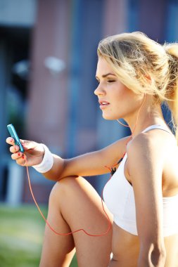 güzel bir kadın fitness şehir üzerinde sırasında müzik dinlemek olduğunu