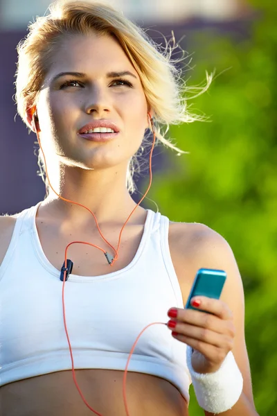 Mujer ajustando música en reproductor de música portátil —  Fotos de Stock