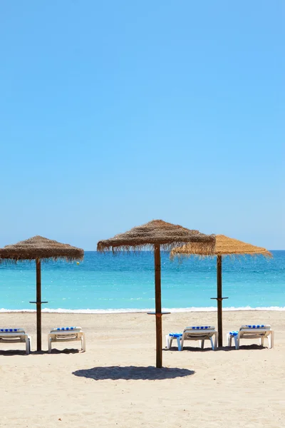 Sun umbrella with chair longues on tropical beach — Stock Photo, Image