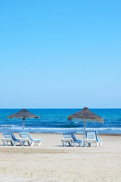 Sombrilla con tumbonas en la playa tropical — Foto de Stock