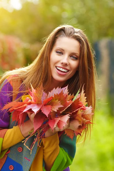 Beautiful elegant woman standing in a park in autumn — Stock Photo, Image