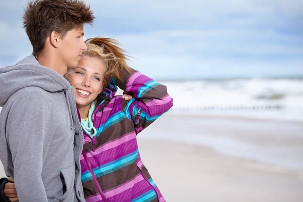 Casal abraçando e se divertindo vestindo roupas quentes — Fotografia de Stock