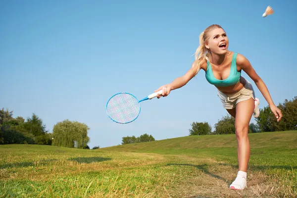 Fitness, jovem mulher jogando badminton em um parque da cidade — Fotografia de Stock