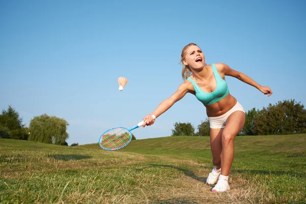 Fitness, jovem mulher jogando badminton em um parque da cidade — Fotografia de Stock