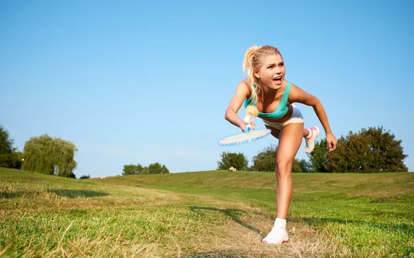 Fitness, jovem mulher jogando badminton em um parque da cidade — Fotografia de Stock