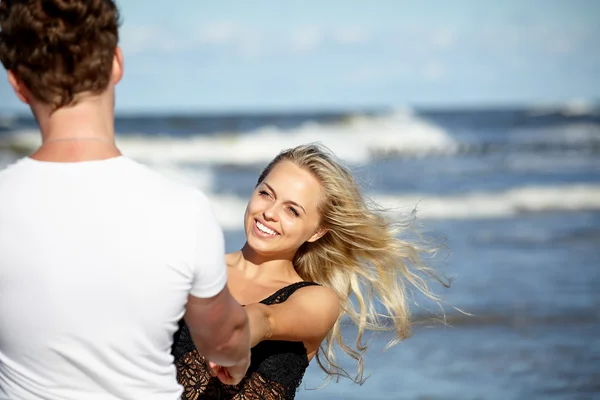 Joven pareja feliz divirtiéndose en la playa . — Foto de Stock