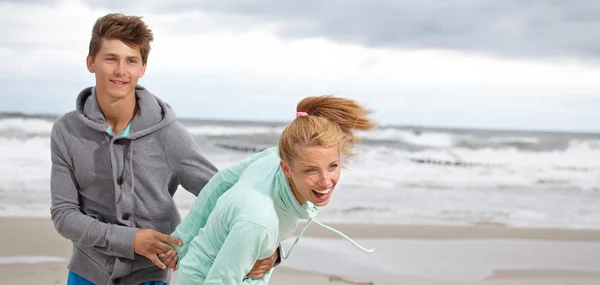 Gülümseyerek elele plajda çalışan çift — Stok fotoğraf