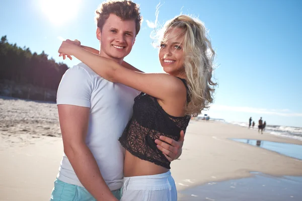 Smiling young couple at beautiful summer beach — Stock Photo, Image