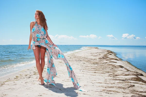 Женщина в синем платье на берегу океана — стоковое фото