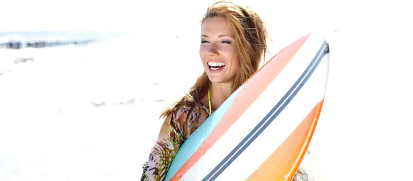 서핑 보드를 들고 해변에 서 있는 여자 — 스톡 사진