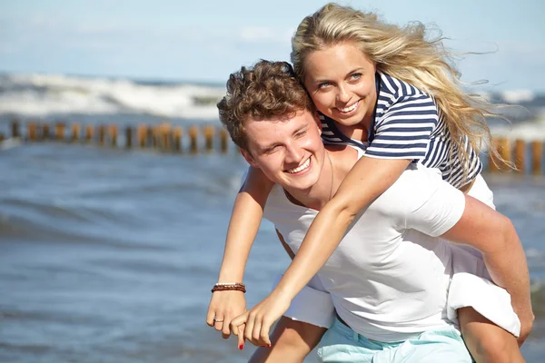 Joven pareja feliz divirtiéndose en la playa . — Foto de Stock