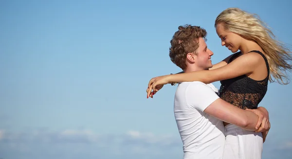 Joven pareja feliz divirtiéndose en la playa . — Foto de Stock