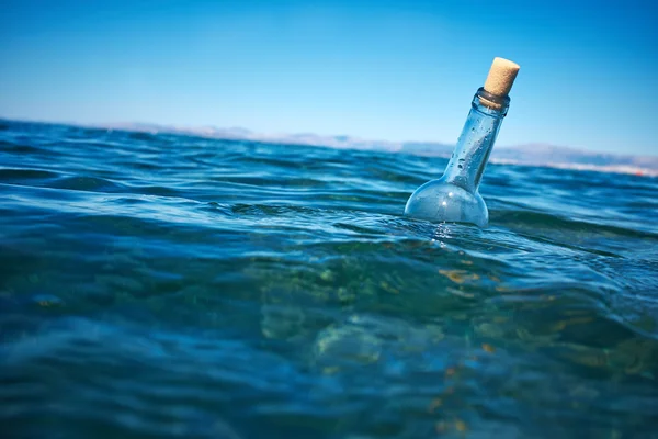 Flasche mit einer Botschaft im Wasser — Stockfoto