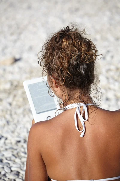 Žena s e-reader na dovolené na pláži, čtení knihy. — Stock fotografie