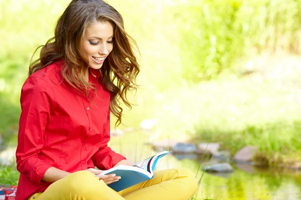 Menina bonita com livro no parque de outono — Fotografia de Stock