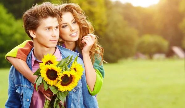 Happy young couple spending time outdoor in the autumn park — Stock Photo, Image