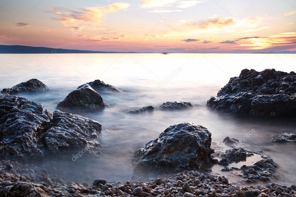 sunrise on rocky sea coast and blurred water