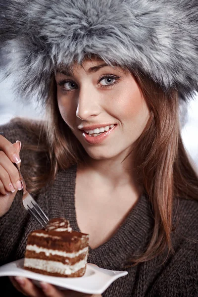 Beautiful winter woman eating cake — Stock Photo, Image