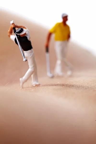 Miniaturfiguren spielen Golf auf nacktem Frauenkörper — Stockfoto