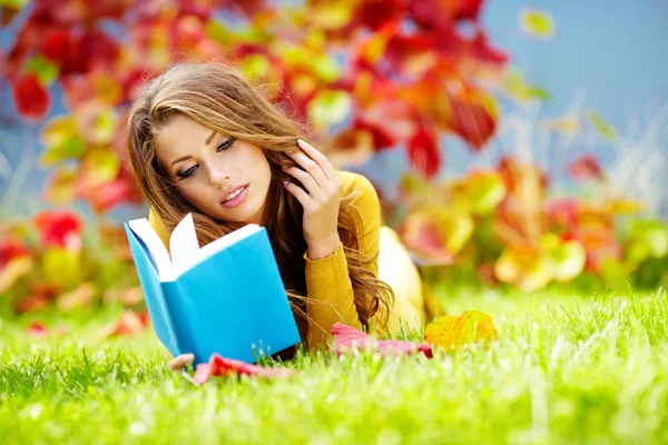 Retrato de una hermosa morena leyendo un libro en el autu —  Fotos de Stock