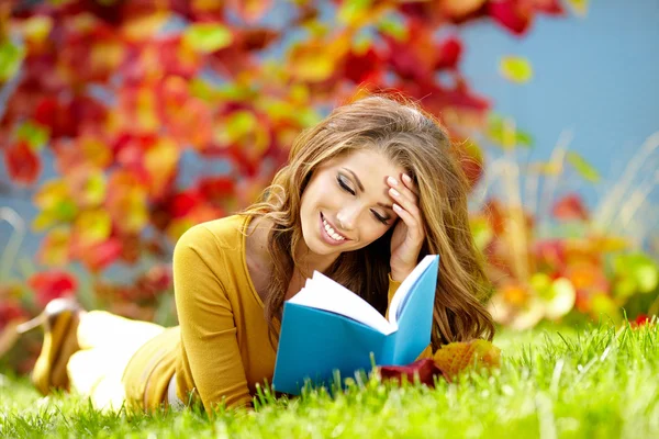 Portret van een prachtige brunette vrouw lezen van een boek in de autu — Stockfoto