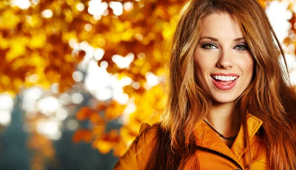 Schöne elegante Frau steht im Herbst in einem Park lizenzfreie Stockfotos