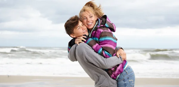 Casal jovem romântico na praia de inverno — Fotografia de Stock