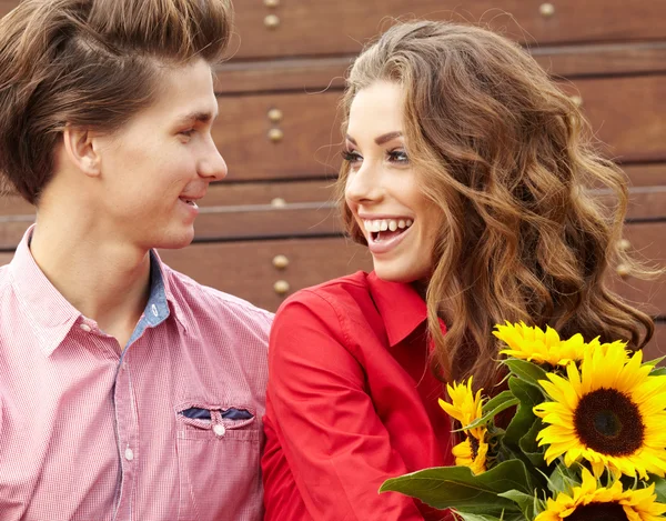 Amour jeune homme étreignant sa petite amie avec des tournesols dans leur — Photo