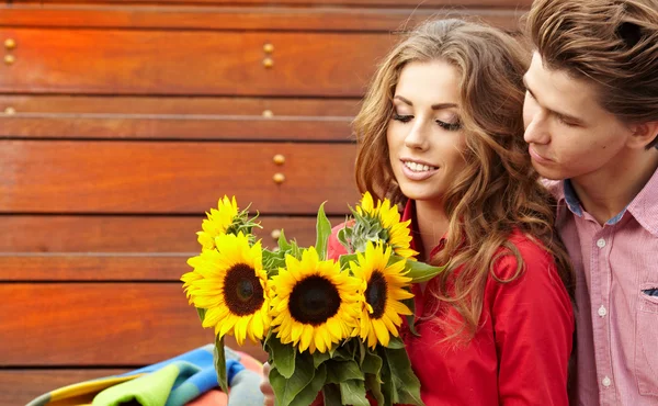 Joven cariñoso abrazando a su novia con girasoles en su —  Fotos de Stock