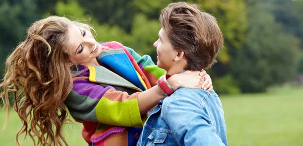 Liefdevolle jongeman knuffelen zijn vriendin met zonnebloemen in hun — Stockfoto