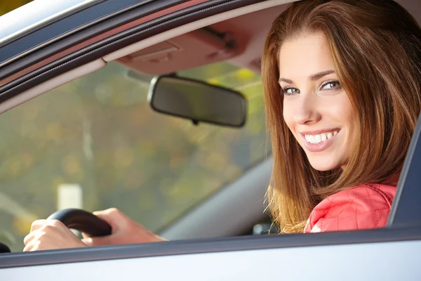 Beautiful young sexy woman in car looking from window on autumn — Stock Photo, Image