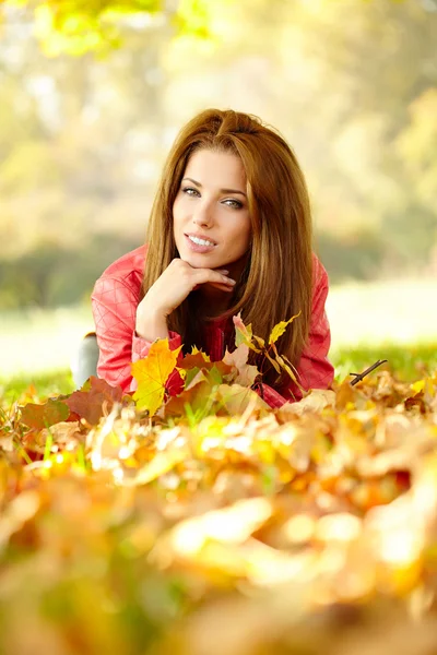 Mujer joven con hojas de otoño en la mano — Foto de Stock