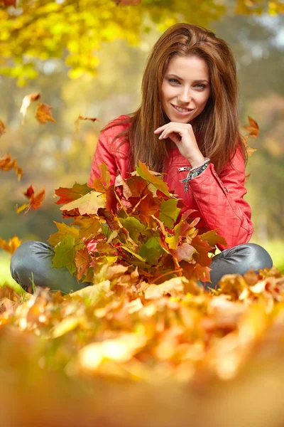 Mujer joven con hojas de otoño en la mano — Foto de Stock