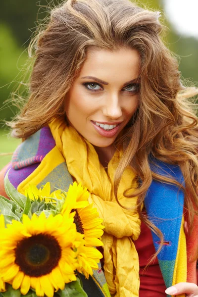 Mujer de moda joven con un ramo de girasoles en el campo —  Fotos de Stock