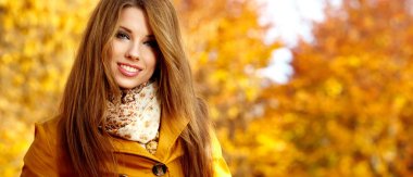 Sonbaharda parkta duran zarif bir kadın.