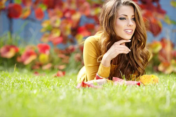 Estudiante sonriendo sobre un fondo de hojas de otoño —  Fotos de Stock