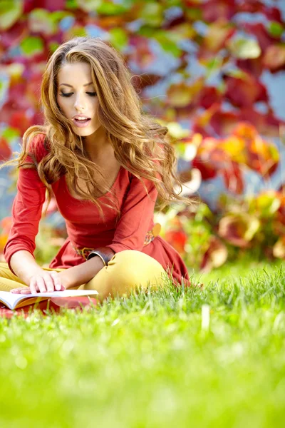 Schönes Mädchen mit Buch im Herbstpark — Stockfoto