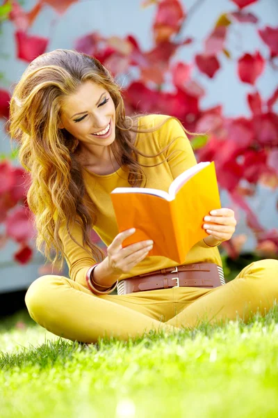 Porträtt av en vacker brunett kvinna läser en bok i hös — Stockfoto