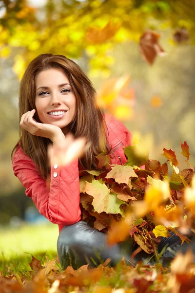 Young woman with autumn leaves in hand and fall yellow maple gar Royalty Free Stock Images