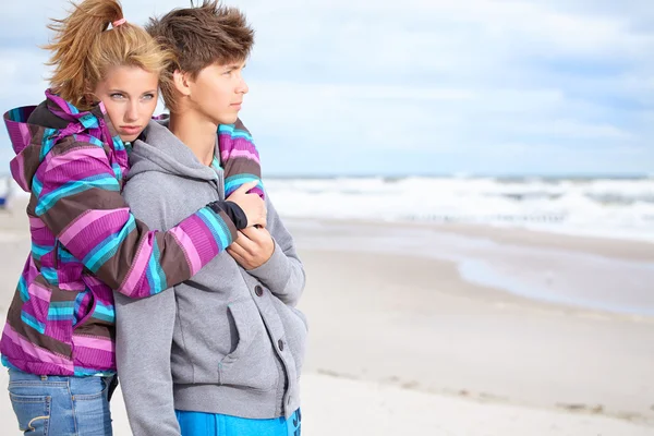 Casal abraçando na costa atrás do céu azul — Fotografia de Stock