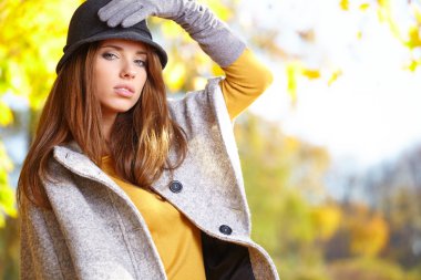 sonbaharda bir parkta duran zarif kadın