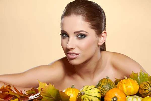 Vrouw met herfst pompoen en bladeren. — Stockfoto