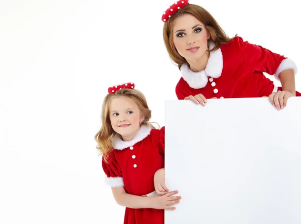 Mooie kerst vrouw en meisje in Kerstman hoed — Stockfoto