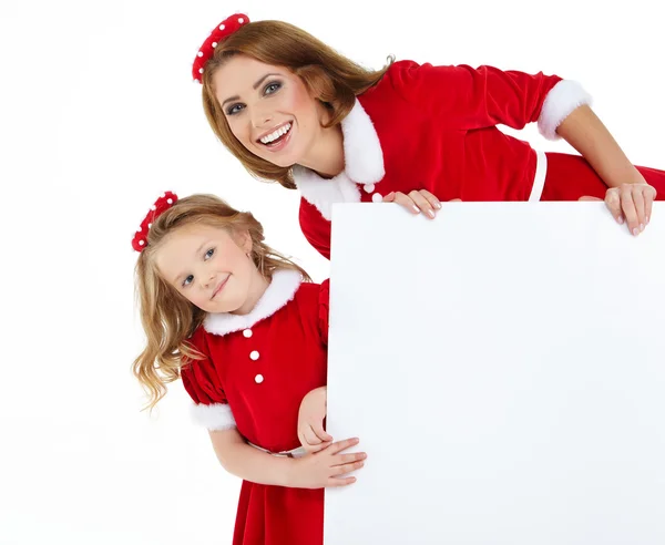 Beautiful christmas woman and little girl in santa hat — Stock Photo, Image