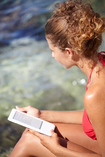 Mujer leyendo ebook en la playa — Foto de Stock