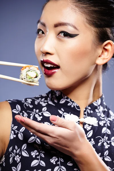 Sushi mujer sosteniendo sushi con palillos mirando a la cámara —  Fotos de Stock