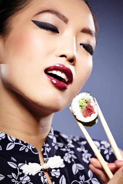 Sushi mulher segurando sushi com pauzinhos olhando para a câmera — Fotografia de Stock